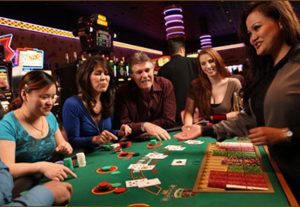 One man and three women looking at the dealer's card in poker