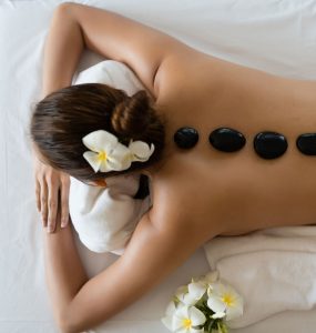Women laying down at spa with hot stones down her back