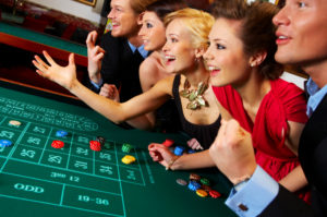 Two men and three women excited rolling the dice